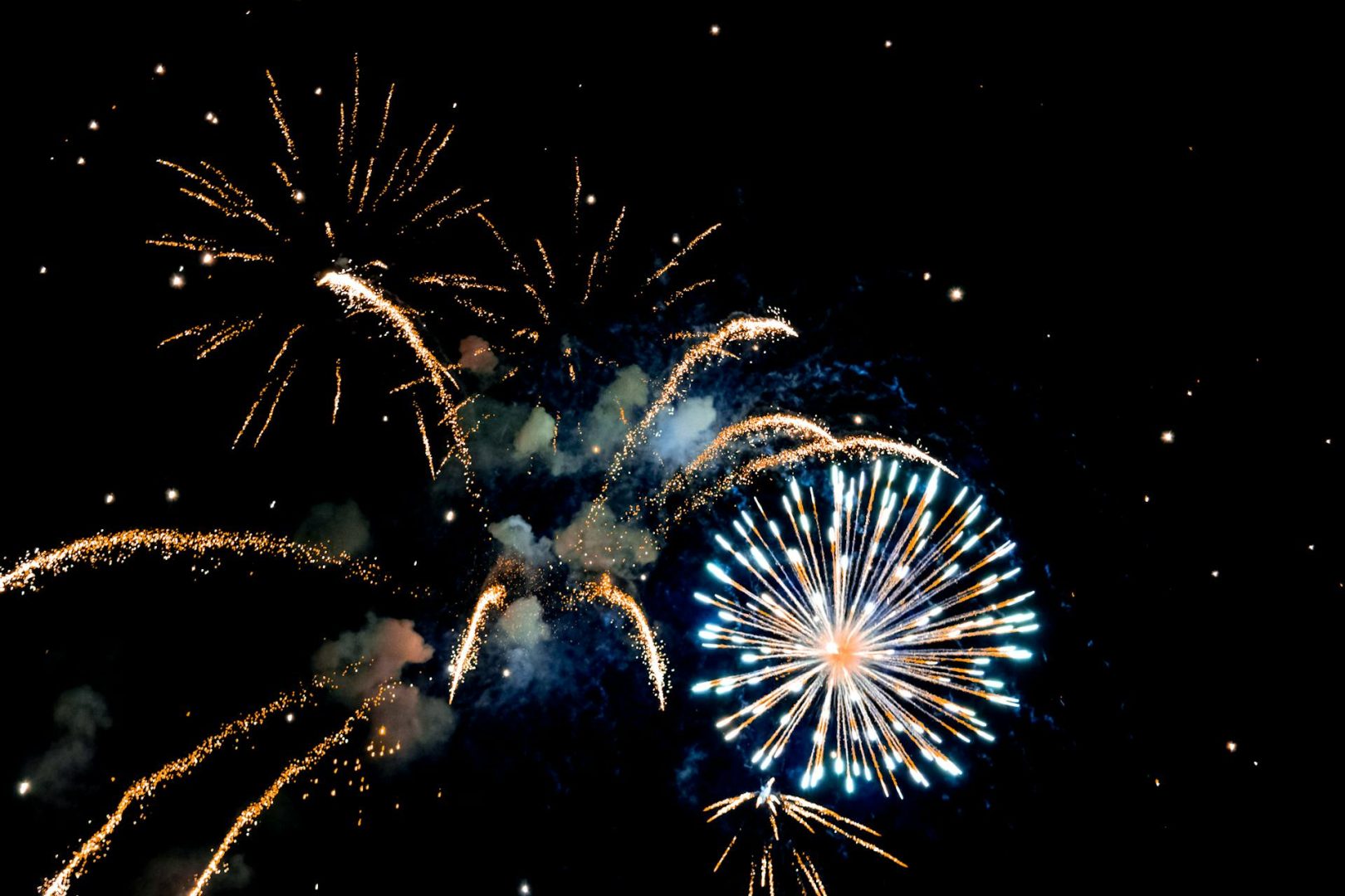 Artillery shell fireworks burst against a black sky